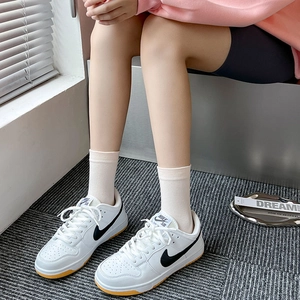 White low-top leather skateboard shoes with black logo and casual crew socks