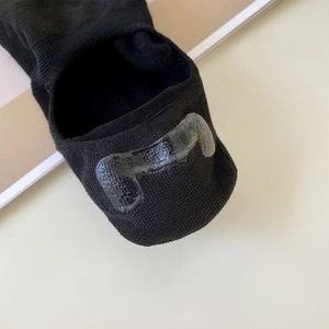 Detail of the non-slip silicone heel grip on a black low-cut cotton invisible sock