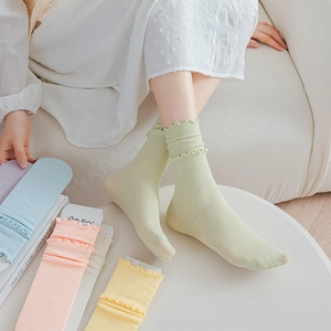 Detail of ruffled cuff socks in pastel colors with vertical ribbed cotton texture