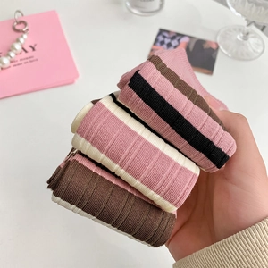 Detailed knit texture of pink and brown striped knee-high socks in Japanese style