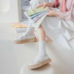 Detail of ruffled cuff socks in pastel macaron colors with vertical ribbing texture