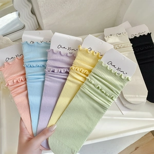 Close-up of ruffled double-layer cuffs on ribbed knit socks in assorted pastel colors