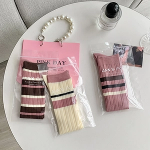 Detailed view of striped ribbed knee-high socks in premium zipper bag packaging
