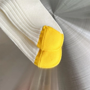 Detail von weißen Rippstricksocken mit kontrastierender gelber Zehenpartie