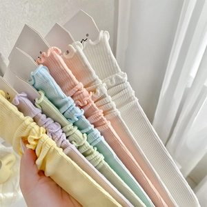 Macro detail of pastel cotton socks with ribbed texture and ruffled lettuce edges
