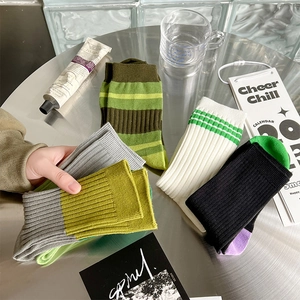 Detailansicht verschiedener gestreifter Baumwollsocken mit Rippmuster auf Metalltisch