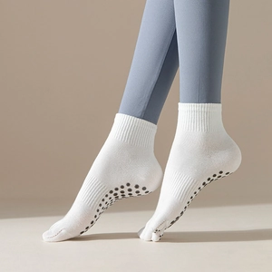 White mid-calf yoga socks with non-slip silicone grips and comfortable ribbed cuffs