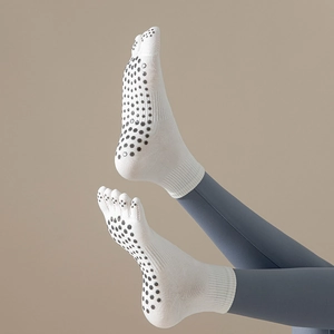 Detail of white five-toe yoga socks with non-slip silicone grips on sole for stability