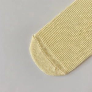 Detail shot of yellow ribbed cotton socks showing precise toe stitching and soft knit texture
