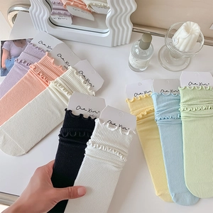 Detail of ruffled cuffs on colorful ribbed cotton socks in a minimalist aesthetic setting