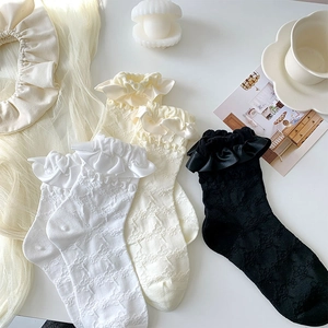 Detail of floral lace trim and satin bow on sweet Lolita style mid-calf socks
