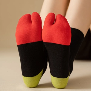 Detail view of stylish three-color split toe tabi socks in red black and green knit