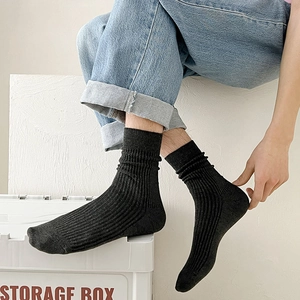 Close-up of black ribbed cotton mid-calf socks worn with denim jeans for casual look