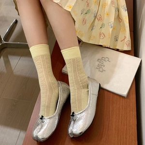 Detail of Lolita silver Tabi flats and heart pattern lace mesh socks on wooden bench