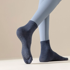 Detailed view of non-slip silicone grips and five-toe design on navy yoga socks