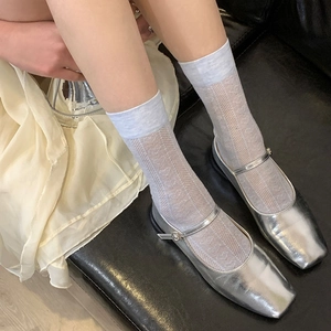 Detail of silver Mary Jane shoes paired with light blue lace hollow mesh socks