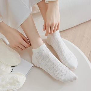 Detailed view of white cotton blend low cut socks with delicate hollowed-out lace patterns