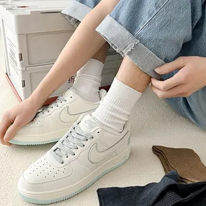 Close-up of white leather casual sneakers featuring a light blue translucent sole