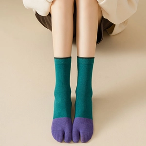 Detail of dark green and purple tabi socks showing ribbed texture and split-toe design