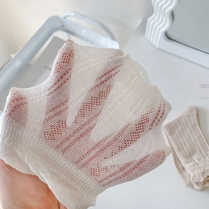 Detail of white hollow mesh socks showing diamond floral knit pattern and breathable texture