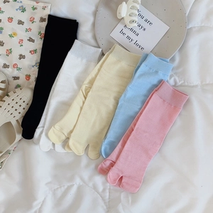 Flat lay of five pairs of cotton tabi socks in pastel colors with ribbed texture details