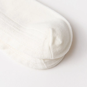 Gros plan sur les coutures de pointe et la maille de chaussettes en coton blanc à dentelle