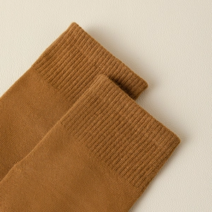 Macro shot of mustard yellow cotton yoga socks featuring high-quality ribbed cuff detail
