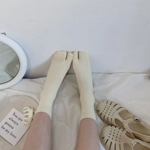 Detail of cream white split-toe socks featuring fine ribbed texture for tabi shoes