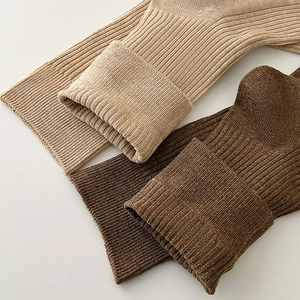 Macro detail of khaki and brown ribbed knit socks showing high-quality fabric texture