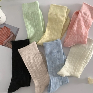 Close-up of heart pattern hollow knit mesh socks in multiple soft pastel colors