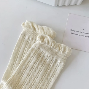 Detail view of cream white mesh knit socks featuring lace trim and ribbed texture
