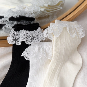 Gros plan sur la maille côtelée et la bordure en dentelle florale des chaussettes