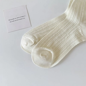 Detailed macro view of white mesh hollow knit pattern on breathable cotton crew socks