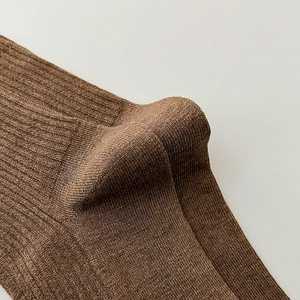 Macro shot of dark brown ribbed knit socks showing the seamless heel and fabric texture