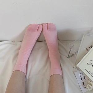 Detailed view of pink cotton two-toe tabi socks for flip-flops in a cozy home setting