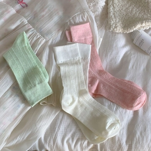 Detailed knit texture of heart-patterned mesh socks in mint green, white, and soft pink colors