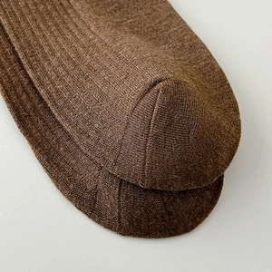 Detailed macro view of the seamless toe stitching and ribbed texture on brown cotton socks