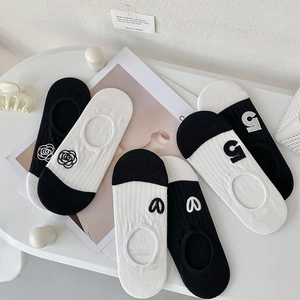 Detail of three pairs of black and white camellia embroidered no-show socks for women