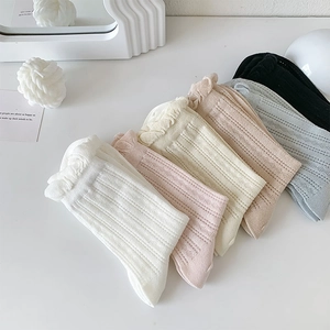 Detail view of colorful rib-knit crew socks with feminine ruffle trim in various pastel colors