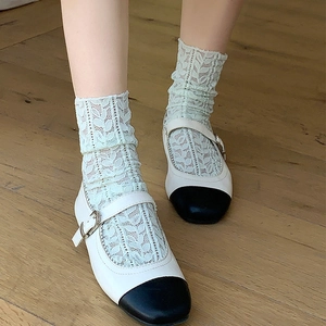 Beige Mary Jane shoes with black toe caps and delicate floral lace mesh socks