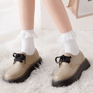 Chaussures richelieu à plateforme beige avec chaussettes dentelle sur tapis