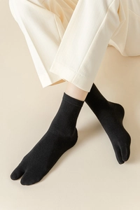 Détail de chaussettes Tabi noires en tricot de coton de qualité à bout fendu