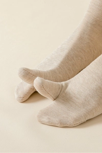 Gros plan de chaussettes à bouts séparés beiges avec texture en maille fine et coutures