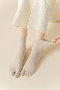 Gros plan de chaussettes à deux doigts beiges élastiques avec texture en maille détaillée