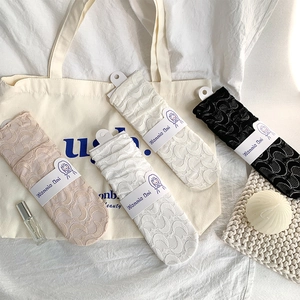 Detail of four-color lace mid-calf socks with crescent patterns and card packaging