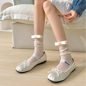 Gros plan de chaussettes en tricot blanc avec nœuds et ballerines élégantes