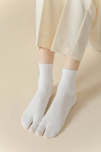 Détail de chaussettes tabi blanches à bout fendu montrant le bord-côte et le coton doux