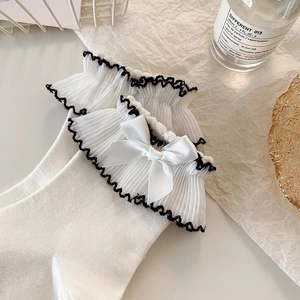 Detailed view of white Lolita socks featuring lace ruffles and a satin ribbon bow detail