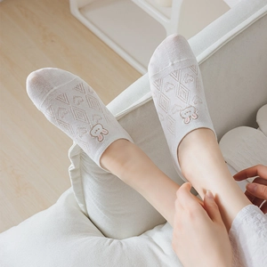 Detail of white low-cut invisible sock featuring cute rabbit embroidery and heart mesh texture