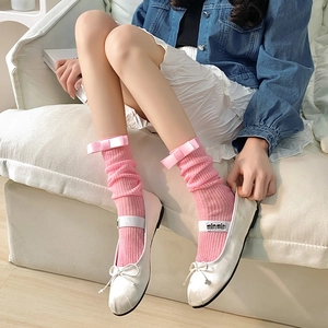 Détail de chaussettes roses à côtes avec nœuds et ballerines blanches de style balletcore